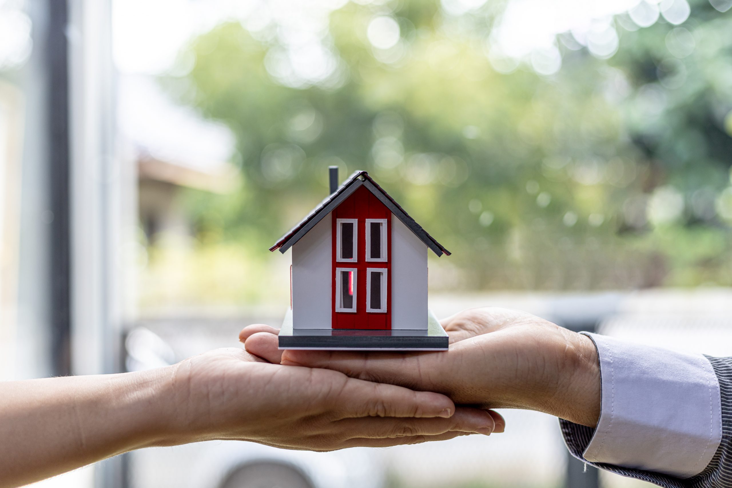 two people holding a miniature house model, photo of home insura